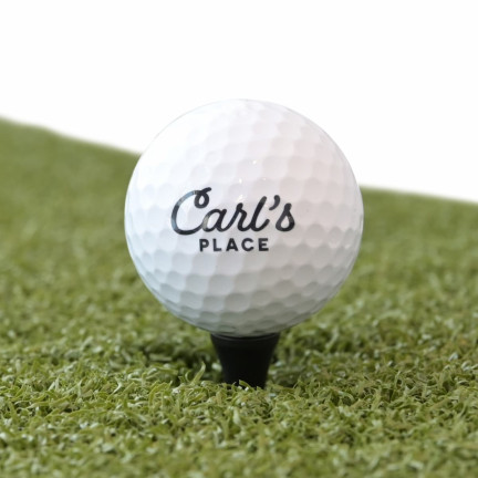 Carl's tee with iron-height golf ball on golf mat